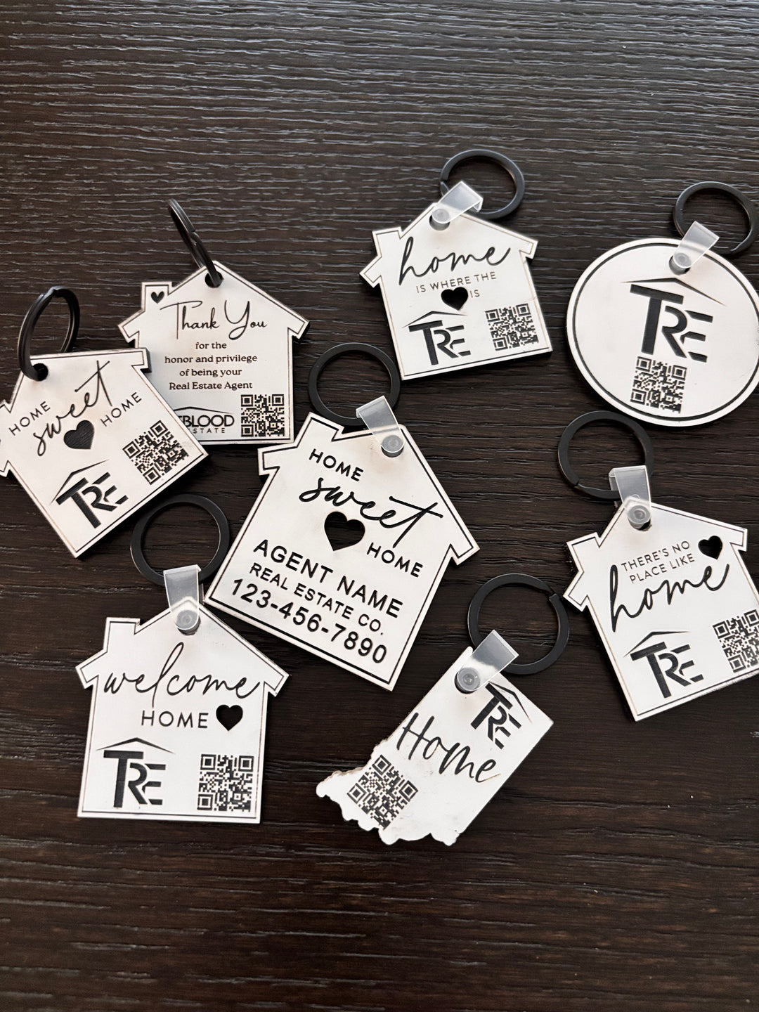 Custom branded house keychains with logo and QR code engraved on white acrylic for real estate closing gifts
