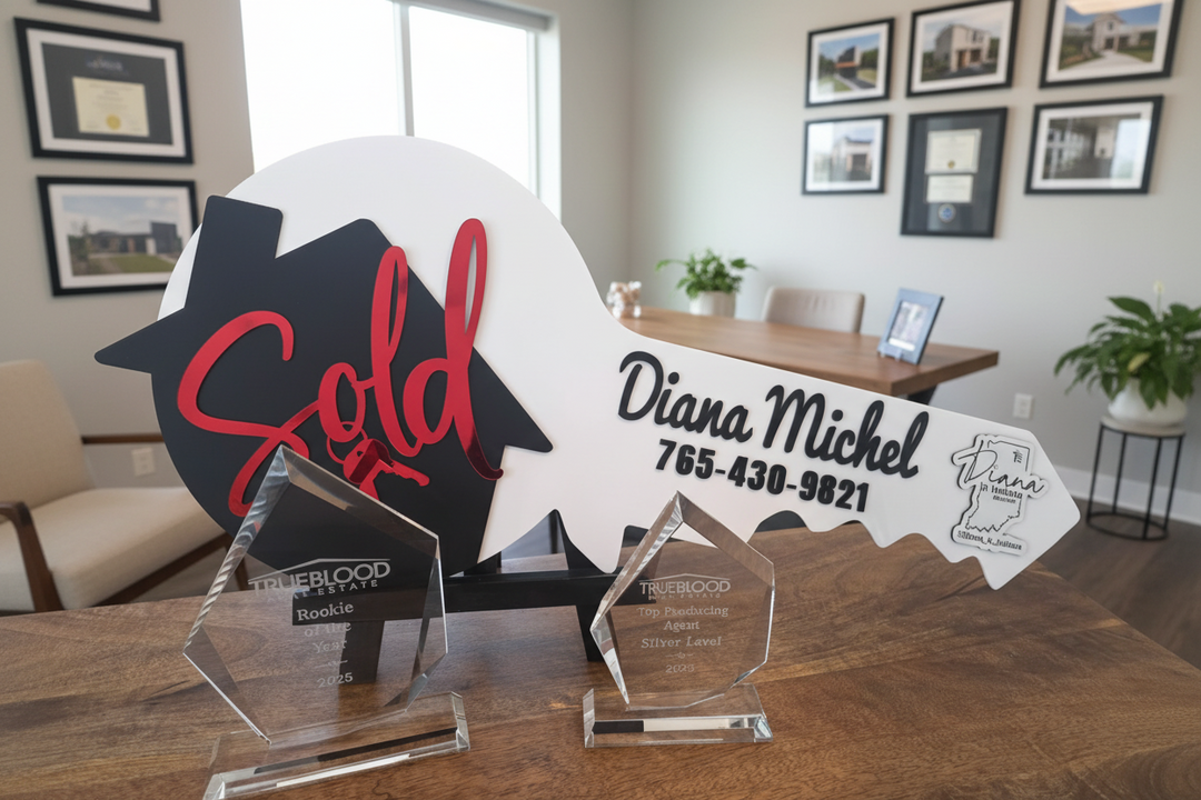 Clients and real estate agent displaying custom “Sold” key photo prop in office for closing day photos and real estate marketing.