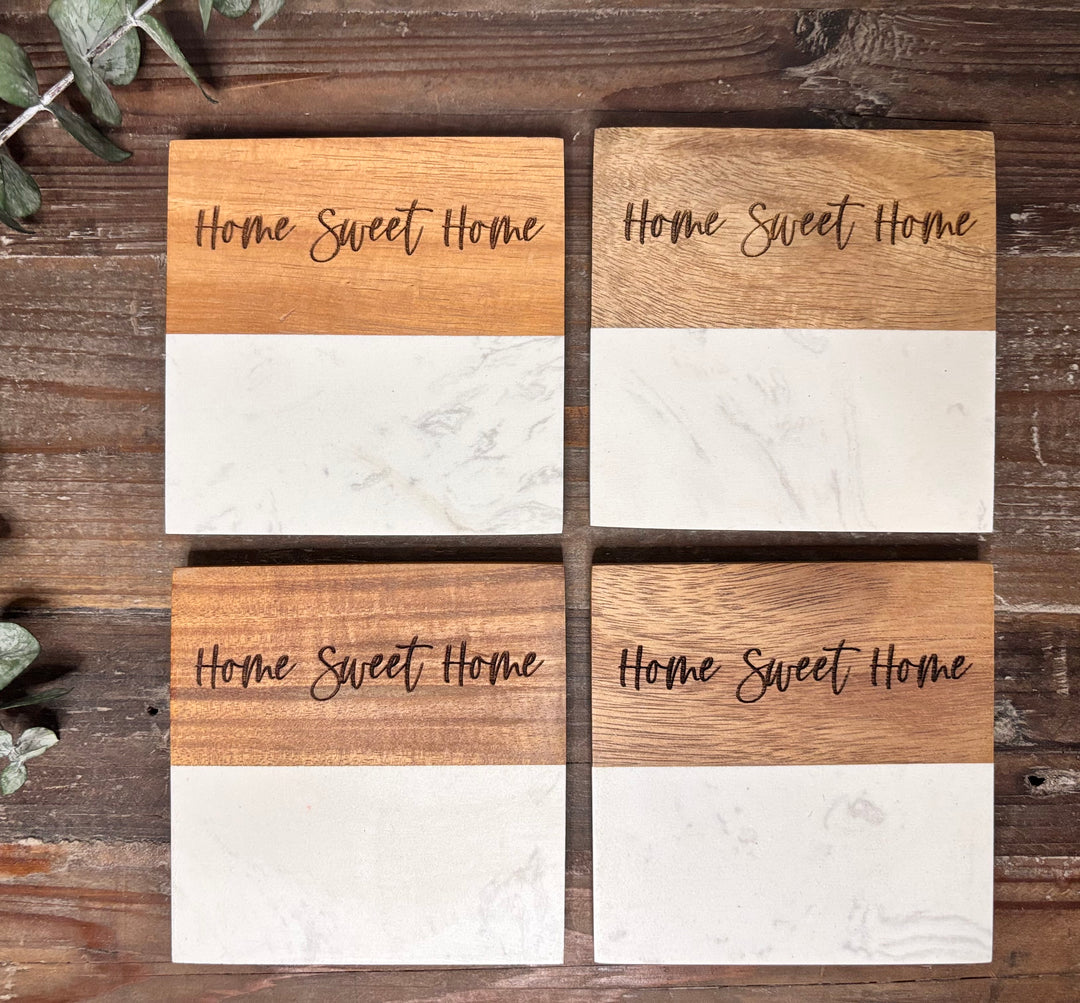 Close up of engraved marble and acacia wood coasters with personalized message detail