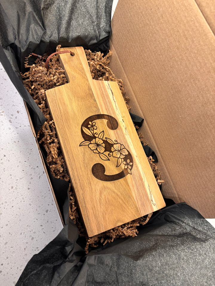 Personalized monogram acacia wood cutting board packaged in gift box for Mother’s Day, birthday, or housewarming gift.