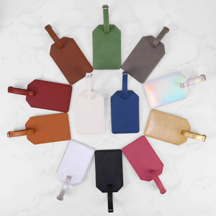 Personalized leatherette luggage tags in multiple colors arranged in circular layout on white background custom engraved travel tags gift