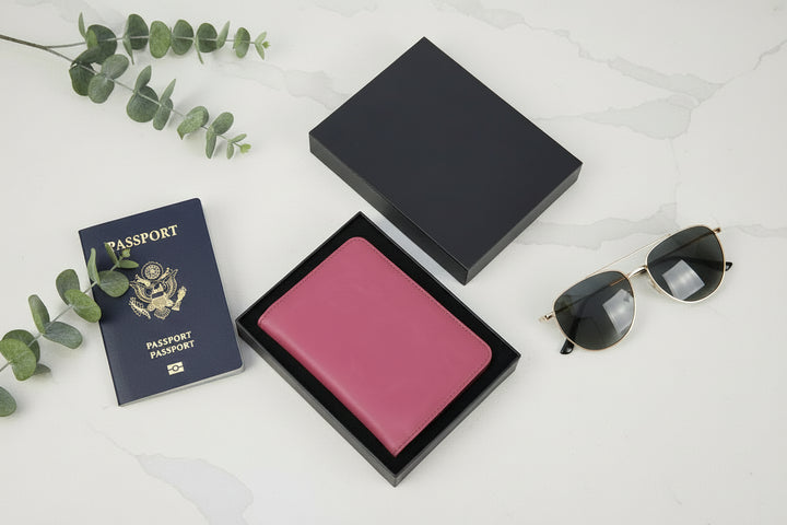 Custom engraved passport wallet in gift box with passport and sunglasses styled travel flatlay for honeymoon destination wedding and travel gifts