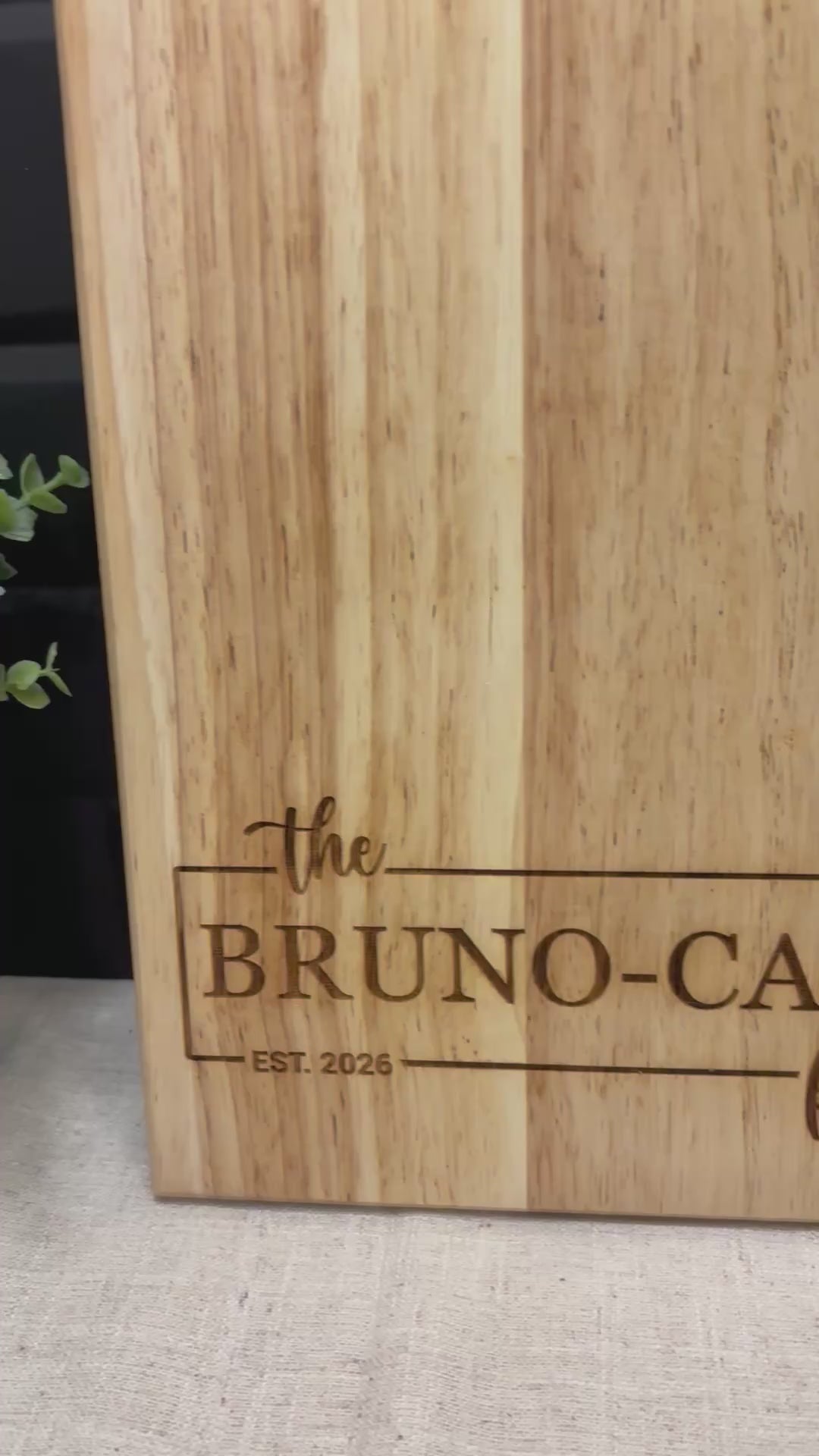 Personalized rubberwood cutting board being engraved with custom family name and date, handmade kitchen gift for weddings and housewarmings