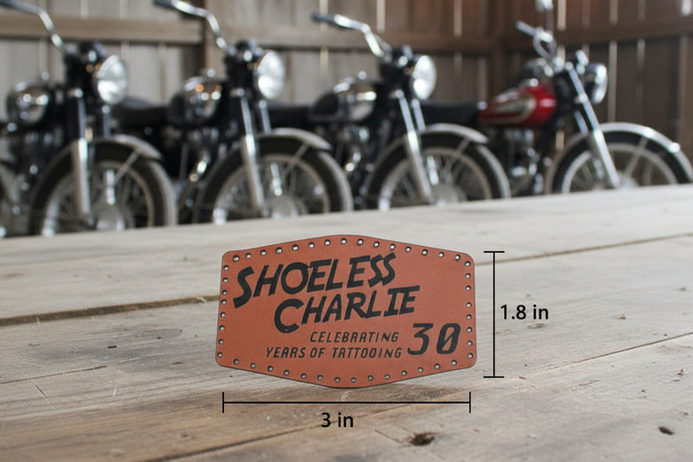 Shoeless Charlie 30th Anniversary leather patch made from genuine brown leather, featuring vintage-inspired design for jackets, hats, and bags.