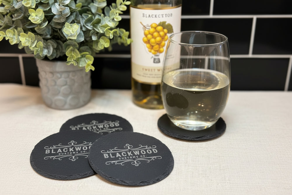 Close-up of engraved company logo on personalized slate coaster
